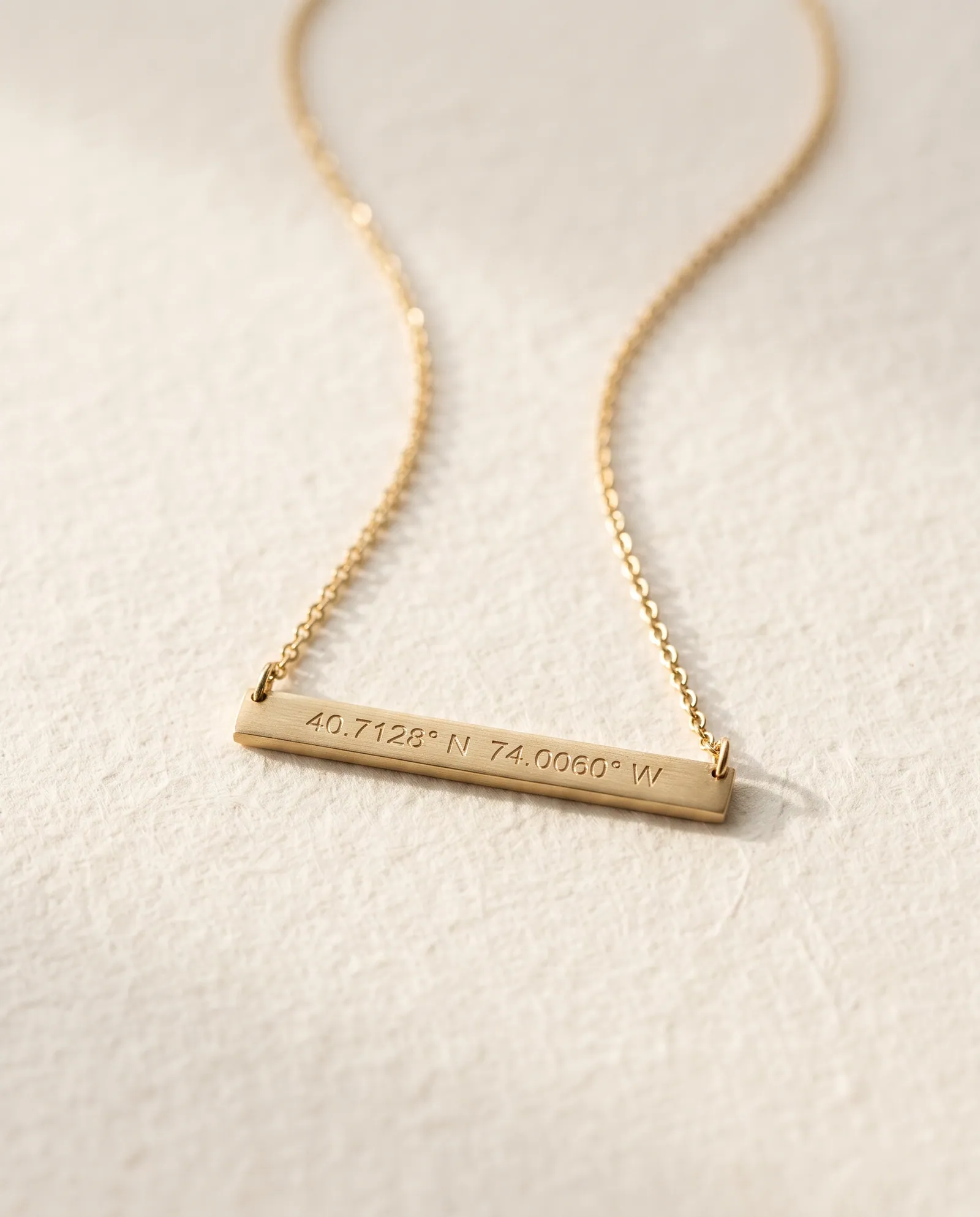 Slim gold-tone bar necklace engraved with map coordinates