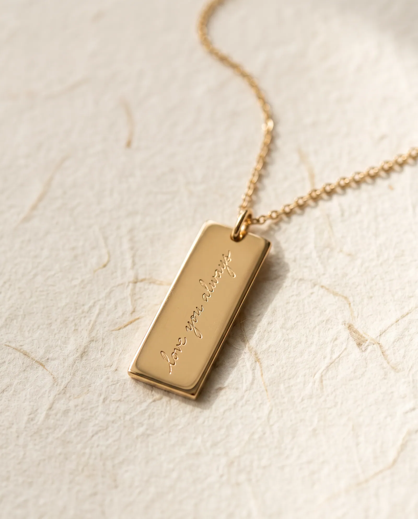 Gold-tone rectangle pendant engraved with handwritten script reading love you always
